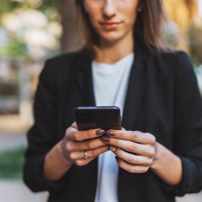 A woman looking down at her smartphone.