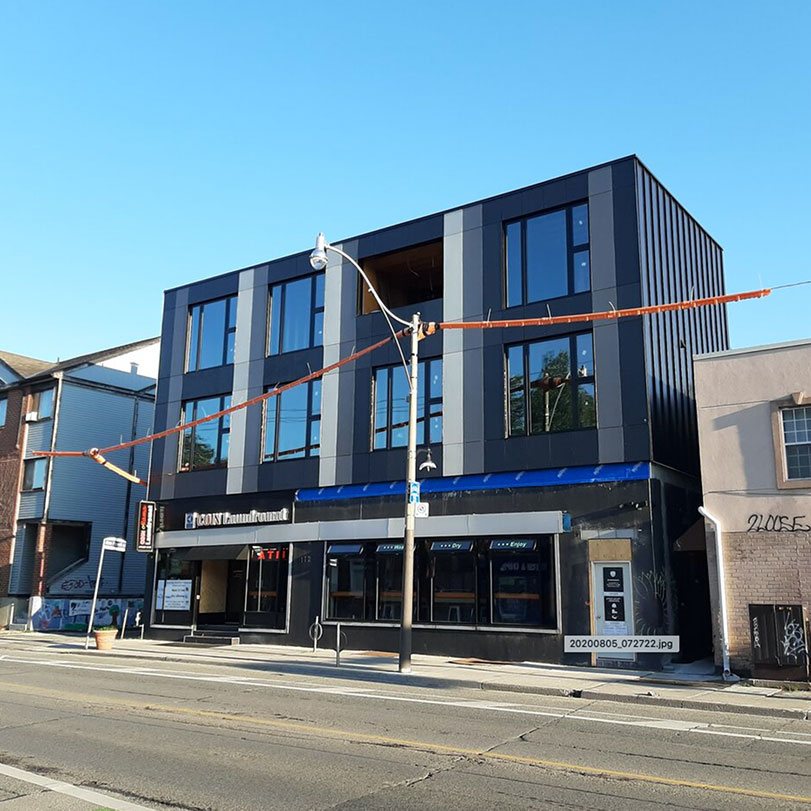 A sleek three-story building on a city street.